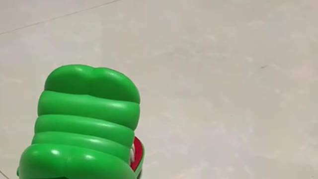 Cute dog is afraid of toy crocodile