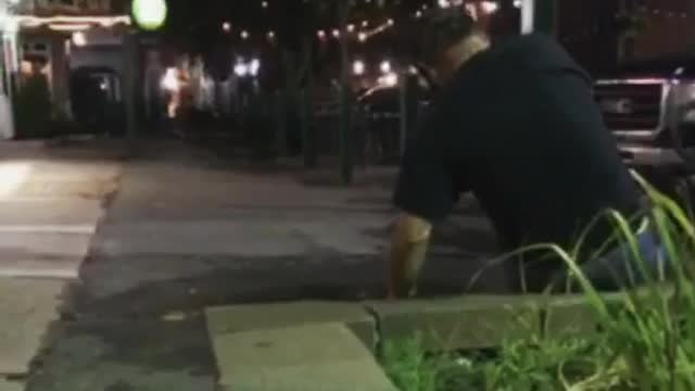 Guy in black shirt leans over and falls down on concrete