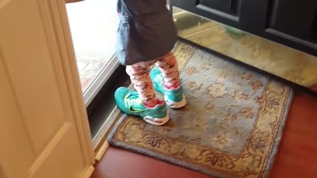 Pequeña lucha por caminar con las zapatillas de su mamá