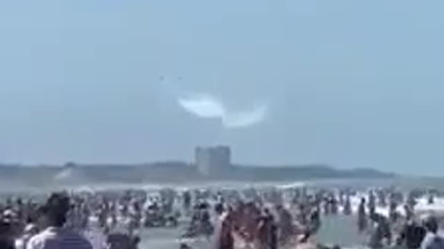 What Is Being Released From These Two Planes Over the Crowd On the Beach?