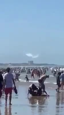 What Is Being Released From These Two Planes Over the Crowd On the Beach?