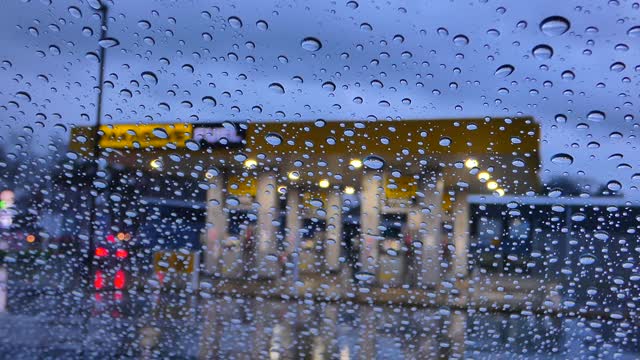 Raindrops on the Windshield of a car at a Gas station