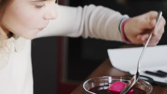 Soaking An Egg On Red Liquid For Coloring