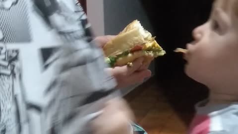 Baby eating burger for the first time