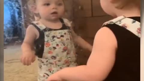 Laughing baby in front of mirror