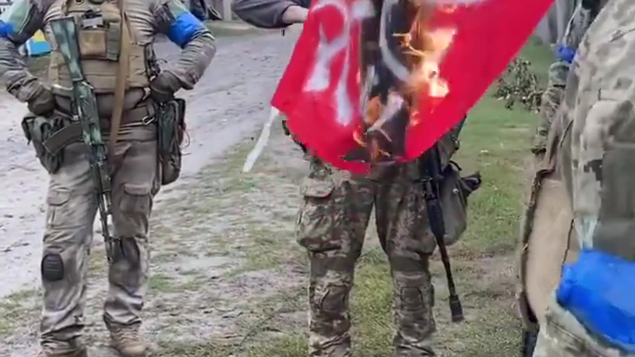 Solados ucranianos queman una bandera comunista