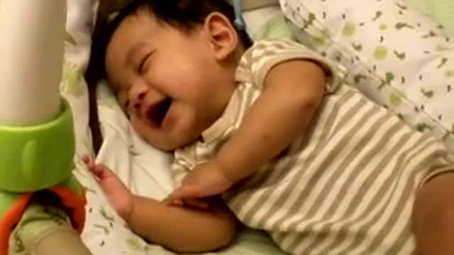 Adorable baby laughing while sleeping