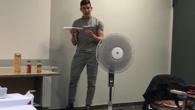 Paper airplane made by kid in grey hits person who filmed