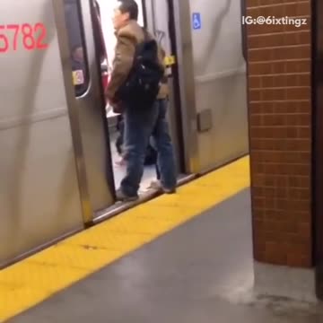 Man in brown jacket stands on doors of subway train