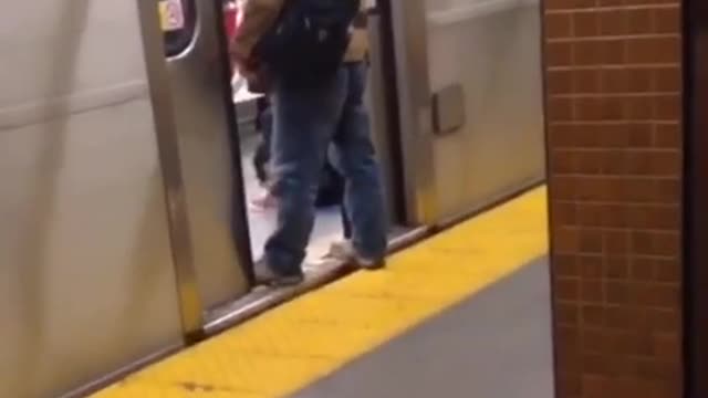 Man in brown jacket stands on doors of subway train