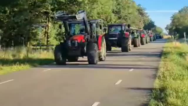 Dutch and German farmers exchange flags at the border before working in tandem