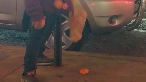 Drunk man tries to pick up oranges and put in bag