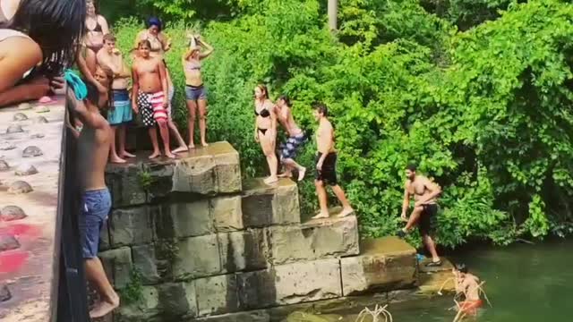 Guy back flip off bridge belly flop lake river water