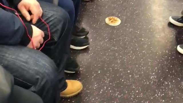 Lady eating off of small plate on subway floor