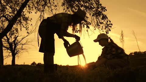 Cows farm concept. Young mother farmer and daughter pour fresh milk