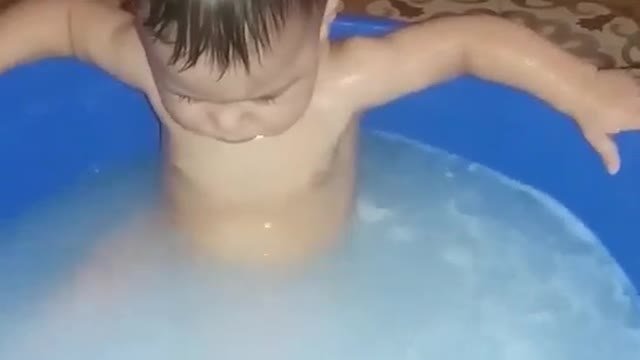 A young child enjoys bathing It's very funny