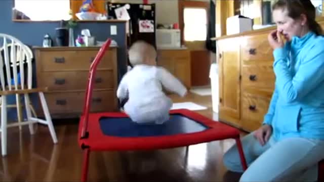 Adorable baby loves jumping on trampoline