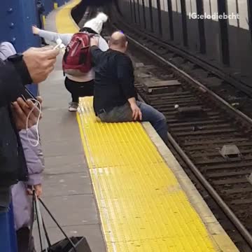 Couple hang feet off subway terminal and get up awkwardly