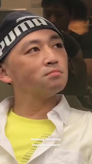 Guy yellow shirt puma beanie looking around subway