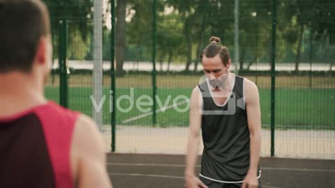 Two Male Basketball Players Passing Ball Each Other During A Training Session In An Outdoor Basketba