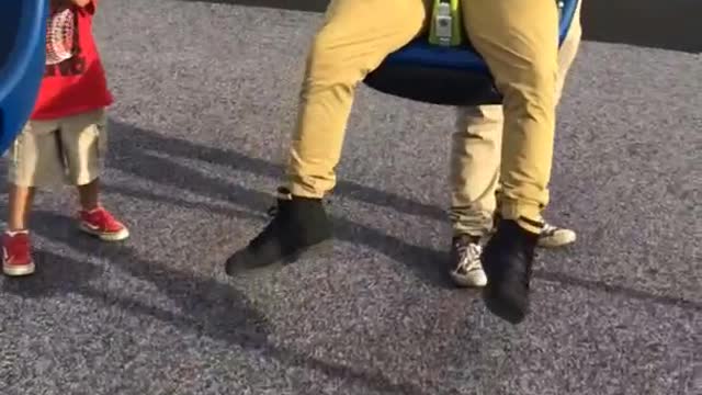 Camera guy hit by guy with glasses in kid swing park