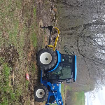 tractor digging holes with a post hole digger