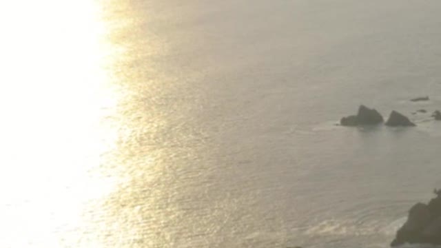 Coast with islands and mountains covered with vegetation during a sunset