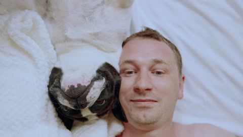 Man and dog lying in bed at home - happy friendship ❤️🤗🐶