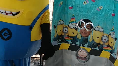 Houston mascot party character minion poses for pictures at the Gru's lab photo prop in Humble, Tx