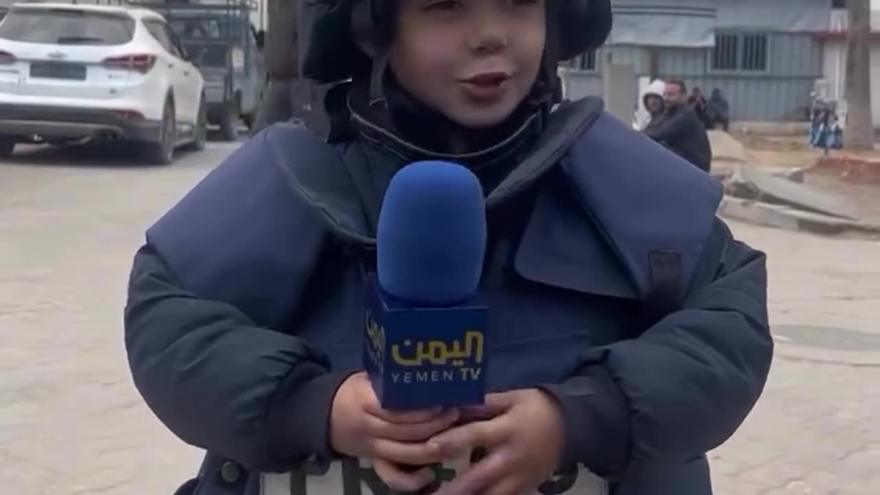 A Pal esti nian child wearing a journalist’s uniform