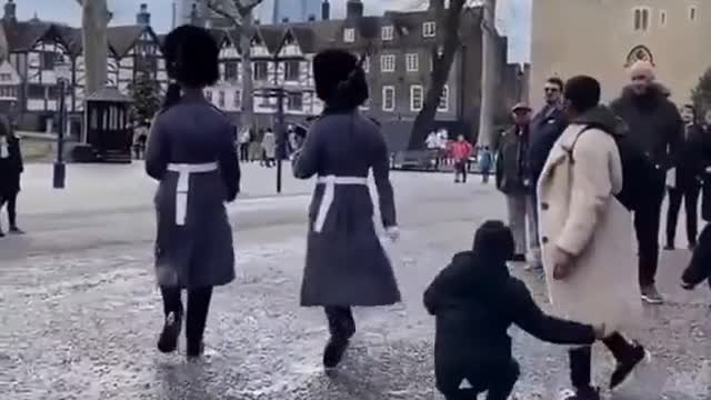 A royal guard knocked down a child during a march at the Tower of London