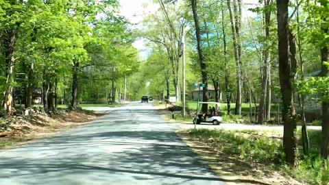 Woman holding a baby driving a golf cart