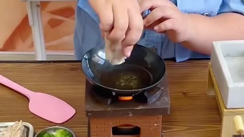 Cute kid cooking on his mini kitchen