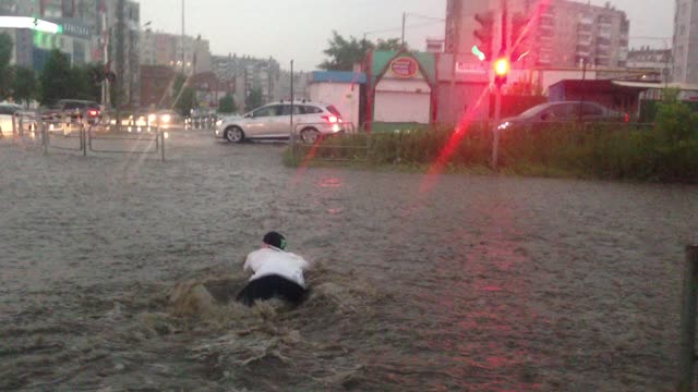 Man Swims Across a Flooded Street