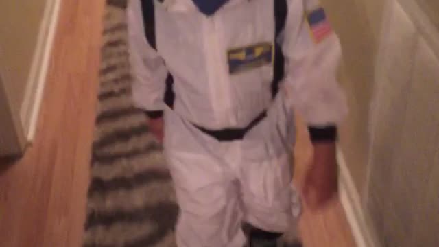 Tot learning to skate in astronaut costume