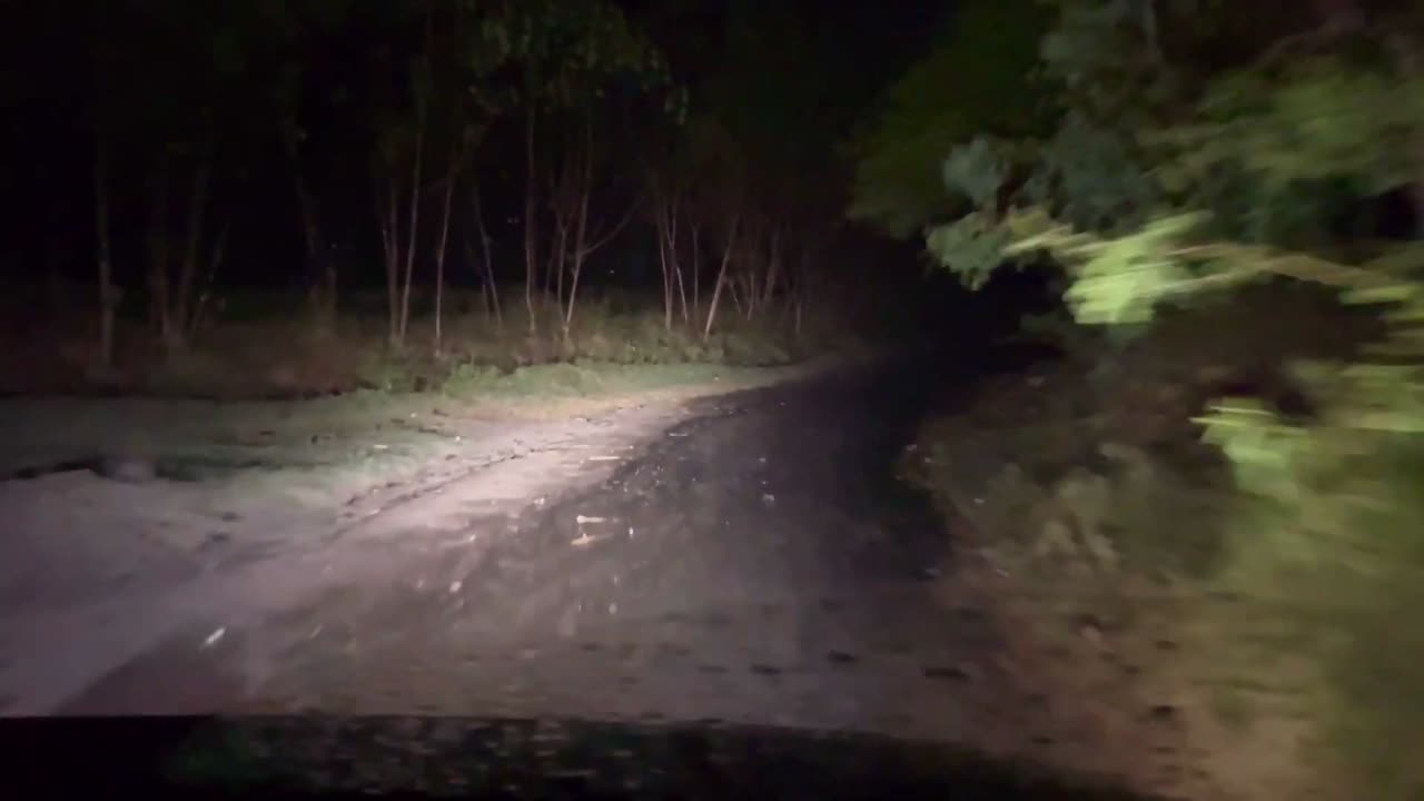 Old graveyard road at night in a rainy weather