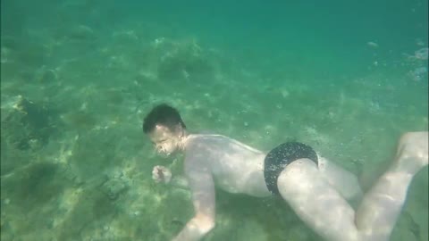 Man Enjoys Swimming Underwater At Beach