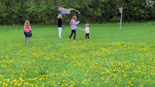 Girls with a friend flying a kite.