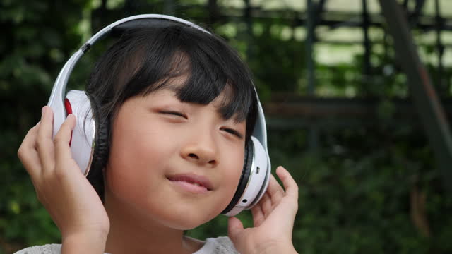 Girl listens to music from headphones and has good feelings.