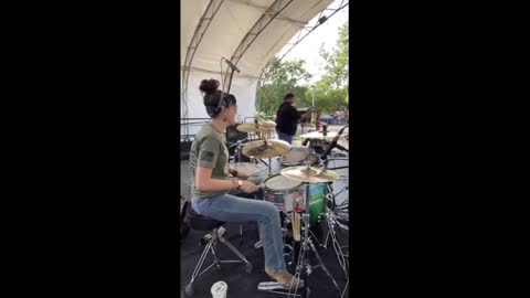 Guitarist begins playing as drummer sips her coffee