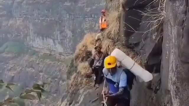 People Trek Through Dangerous Cliff