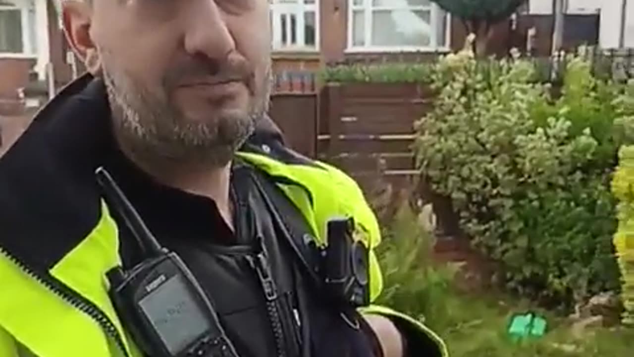 A UK police officer pays a home visit to a man for hanging a PALESTINIAN flag out of his window