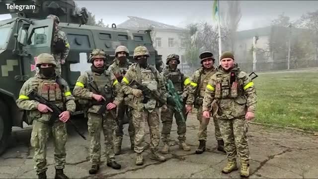 Ukrainian soldiers wave flags in village of Kyselivka in Kherson Oblast after Russia's withdrawal