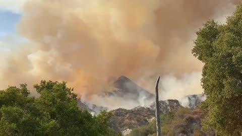 Dark Smoke Engulfs Clear Sky As Wildfire Spreads With Onshore Winds in California