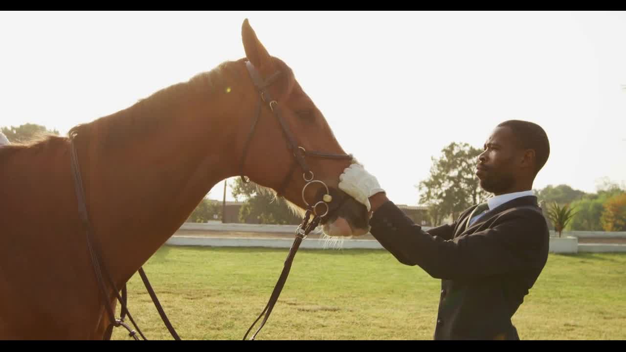 African American man looking at his dressage horse