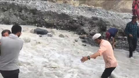 Hunza lady cross a glaciiers water