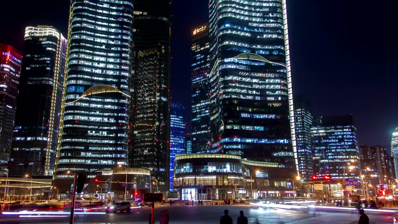 Looking up at large buildings in a city at night