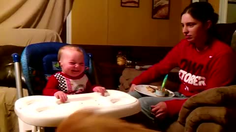 Baby can't stop laughing at dog eating green beans