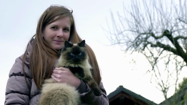 Woman and cute cat portrait outside in nature