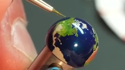 Hand_painting_a_globe_for_a_$570,000_JLC_clock